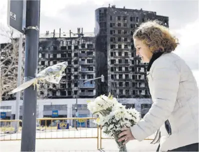  ?? Ana Escober / Efe ?? Una dona deixa flors en memòria de les víctimes mortes en l’incendi del complex de València.