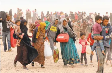  ?? Khalil Mazraawi / AFP / Getty Images 2016 ?? Syrian refugees carry their belongings as they wait to enter the Jordanian side of the Hadalat border crossing, a military zone east of the capital Amman, after arriving from Syria.