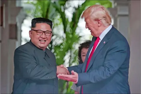 ?? KEVIN LIM/THE STRAITS TIMES VIA AP ?? President Donald Trump shakes hands with North Korea leader Kim Jong Un at the Capella resort on Sentosa Island in Singapore today.