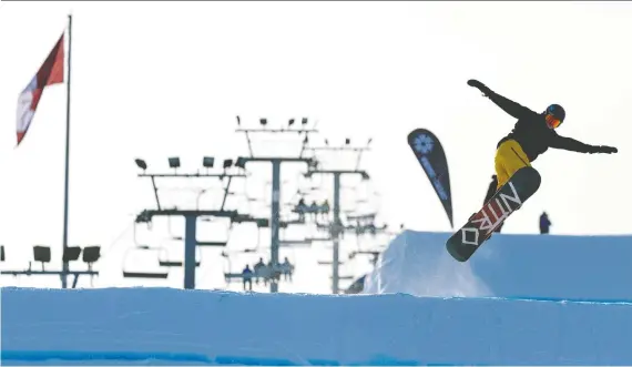  ?? AZIN GHAFFARI ?? A snowboarde­r makes a jump off a ramp Wednesday at Winsport, where the protocols to prevent the spread of COVID-19 are constantly changing and evolving.