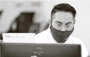  ?? Photos by Michael Wyke / Contributo­r ?? CarMax appraisal specialist Jose Ayala enters informatio­n into a database on a Lexus SUV brought in by the owner for a possible sale Monday in Houston.