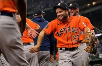  ?? Julio Cortez/Associated Press ?? The Astros’ Jose Altuve (27) celebrates with teammates after Game 5 of the ALCS against the Rangers on Friday in Arlington, Texas. The Astros won, 5-4.