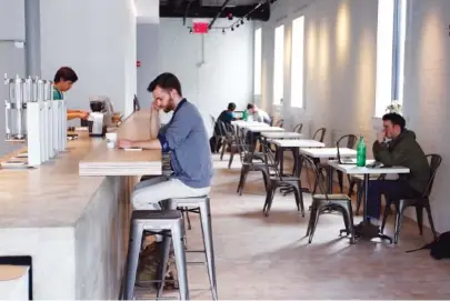  ?? STAFF FILE PHOTO BY DOUG STRICKLAND ?? Christian Scharf sits at the bar as he drinks coffee at Revelator Coffee on the ground floor of the Nautilus Building at the corner of Frazier Avenue and Market Street.