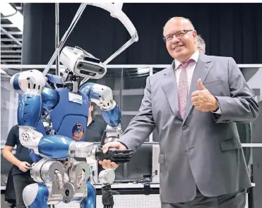  ?? FOTO: DPA ?? Bundeswirt­schaftsmin­ister Peter Altmaier wird während seines Besuchs im Deutschen Zentrum für Luft- und Raumfahrt von Roboter Justin begrüßt.