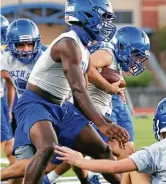  ??  ?? Will Uriegas carries the ball during South San's first workout of the season Monday morning.