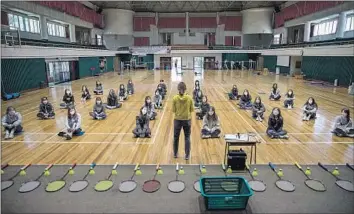  ?? Woohae Cho For The Times ?? STUDENTS at Gyungbuk Girls’ High School in Daegu, South Korea, gather in the gym for PE. High school seniors across the nation resumed classes this week after lengthy closures due to the coronaviru­s outbreak.