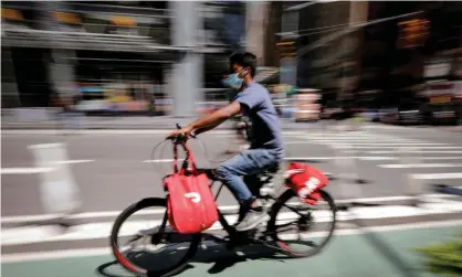  ?? Photograph: Mike Segar/ Reuters ?? A rider for Grubhub food delivery service rides a bicycle during a delivery in midtown Manhattan, New York.