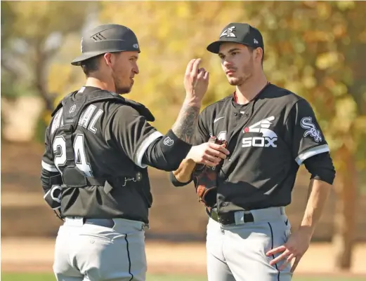  ?? JOHN ANTONOFF/FOR THE SUN-TIMES ?? Yasmani Grandal, a great pitch-framer, and right-hander Dylan Cease discuss a bullpen session they just finished at Camelback Ranch.