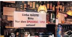  ?? FOTO: CLAUDIA HAUSER ?? Die Gäste der Kölner Kneipe „Alt Neppes“wurden mit einem Schild angewiesen, sich vor den Spuckschut­z zu setzen.