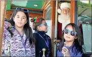  ?? / Doug Walker ?? Reese Torimoto (from left), Madyson Thacker and Ella Torimoto enjoy a trolley ride with Santa on Saturday.