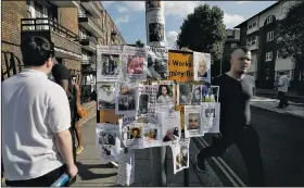  ?? AP/KIRSTY WIGGLESWOR­TH ?? Posters of missing people cover a sign Saturday near the site of the Grenfell Tower fire in London.