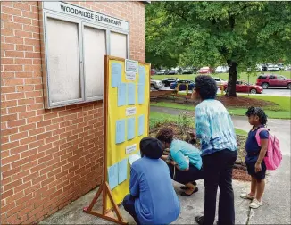  ?? AJC FILE ?? Parents at DeKalb County’s Woodridge Elementary School check out classroom assignment­s on the first day of the 2016-17 school year. The right teacher can have a profound effect on how much a student learns, and some parents begin angling to get their...