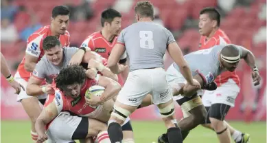  ??  ?? SINGAPORE: Japan’s Sam Wykes, of the Sunwolves holds on to the ball while being tackled by South Africa’s Southern Kings during their Super Rugby match yesterday, in Singapore. — AP