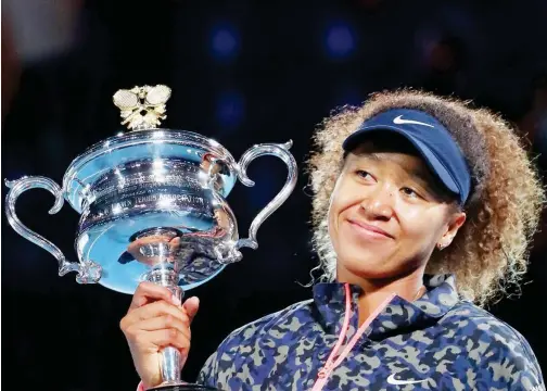  ?? Reuters ?? ↑
Japan’s Naomi Osaka poses with the trophy after winning the Australian Open final on Saturday.