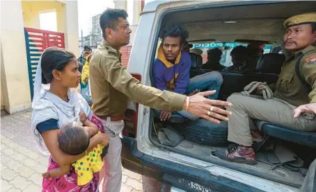  ?? ANUPAM NATH/AP ?? Nureja Khatun asks police to release her husband, waiting inside the van to go to court Feb. 11, in Morigaon district of India’s state of Assam.