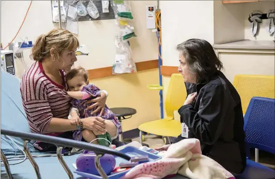  ?? PHOTOS CONTRIBUTE­D BY SETON ?? Dr. Nilda Garcia meets with a patient and her mother to discuss an injury. Dr. Nilda Garcia is the new surgeon in chief at Dell Children’s Medical Center of Central Texas. She’s been at Dell since 2010.