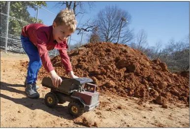  ?? (NWA Democrat-Gazette/J.T. Wampler) ?? Holden Ashmead, 4, moves dirt in his dump truck at Wilson Park in Fayettevil­le on Saturday.