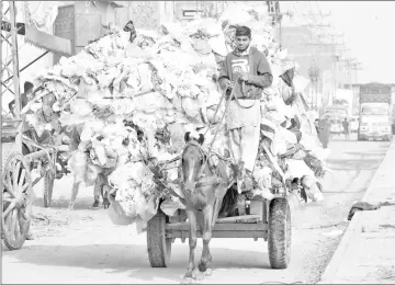  ?? — AFP photo ?? A Pakistani boy carries waste plastic bags on a horse-driven cart in Lahore.