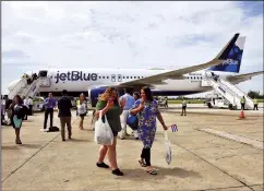  ?? YAMIL LAGE/AFP VIA GETTY IMAGES/TNS ?? In this photo from Aug. 31, 2016, passengers deplane upon arriving at the airport of Santa Clara, Cuba, on the first commercial flight between the United States and Cuba since 1961.