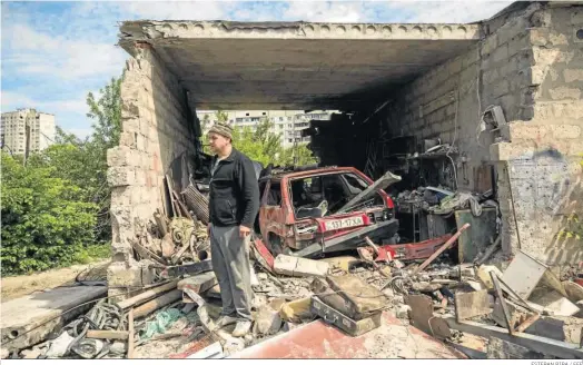  ?? ESTEBAN BIBA / EFE ?? Un residente de Jarkov permanece sobre los escombros de su garaje, destruido por un misil ruso.
