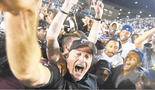  ?? MICHAEL SHROYER/GETTY IMAGES PHOTOS ?? Old Dominion coach Bobby Wilder celebrates with students and fans after the Monarchs, who were 28.5-point underdogs, upended No. 13 Virginia Tech at Ballard Stadium in Norfolk.