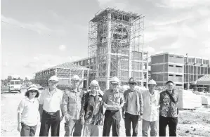  ??  ?? LEE (lima kiri), Dr Bolhassan (empat kiri) bersama yang lain bergambar di hadapan bangunan SMK Tudan yang dalam proses pembinaan. Turut kelihatan ialah Pengurus Tapak Pembinaan, Low Ing Huat (tiga kiri) yang mewakili pihak pemaju, Kurnia Matang Sdn Bhd.