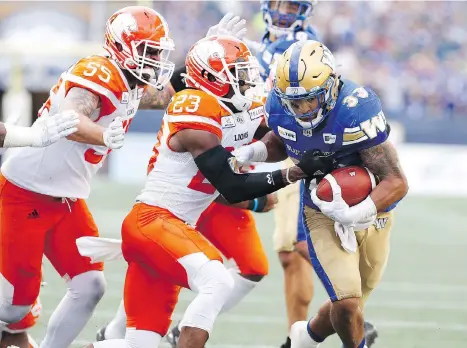  ?? JOHN WOODS/THE CANADIAN PRESS ?? Lions defender Anthony Thompson can’t stop the Bombers’ Andrew Harris in the first half Saturday in Winnipeg.