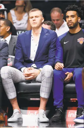  ?? Noah K. Murray / Associated Press ?? New York Knicks forward Kristaps Porzingis sits on the bench during the second quarter of the team’s preseason game against the Brooklyn Nets on Oct. 3 in New York.