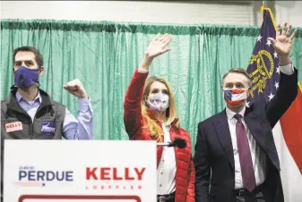  ?? Jessica McGowan / Getty Images ?? Sen. Kelly Loeffler and Sen. David Purdue wave to supporters at a rally with Sen. Tom Cotton (left) in Perry, Ga. They face Democrats Jon Ossoff and Raphael Warnock in a Jan. 5 runoff.