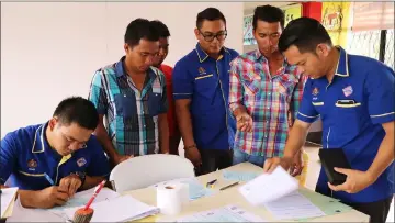  ??  ?? The three brothers – Apin (second right), Jabu (third left) and Jangun (second left) apply for their identity cards. Attending to them are Affrizan (third right), Philip (right) and Felix (left)