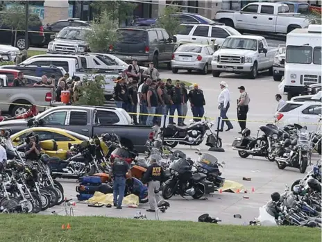  ?? JERRY LARSON/THE ASSOCIATED PRESS ?? Authoritie­s investigat­e a shooting Sunday in a restaurant parking lot in Waco, Texas. Police say nine members of rival biker gangs were killed.