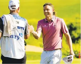  ?? MATT YORK AP ?? Cameron Smith celebrates with caddie Sam Pinfold after winning the PGA Tournament of Champions by one stroke over world No. 1 Jon Rahm on Sunday in Kapalua.