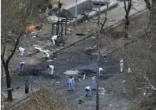  ??  ?? Forensic officers work on Tuesday at the site of Sunday’s suicide car bombing that killed 37 people in Ankara.