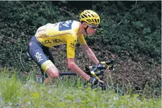  ?? CHRISTOPHE ENA/THE ASSOCIATED PRESS ?? Chris Froome, wearing the overall leader’s yellow jersey, speeds downhill during the ninth stage of the Tour De France Sunday stretching from Nantua, France, to Chambery, France.