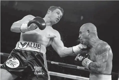  ?? ASSOCIATED PRESS ?? Miguel Cotto, right, of Puerto Rico, get hits by Canelo Alvarez, of Mexico, during a WBC middleweig­ht title bout in Las Vegas.