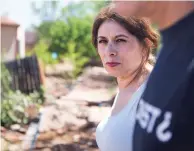  ?? OLIVIA HARLOW THE NEW MEXICAN ?? Gladys Trujillo surveys the damage to her yard following Monday night’s flash flood. A wall was knocked over and her home flooded.