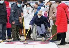  ??  ?? Locals try their hand at curling at Beijing’s Shougang Industrial Park as part of a Paralympic promotiona­l event on Wednesday.