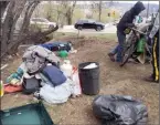  ?? Special to The Herald ?? An RCMP officer assists with dismantlin­g a highly visible homeless encampment last month along Industrial Avenue in Penticton.