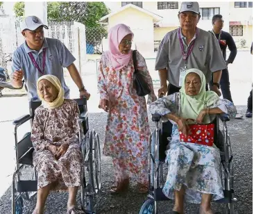  ?? the polling centre. ?? Still going strong: (From left) Suyong, Enong and Hairiah posing for reporters after arriving at