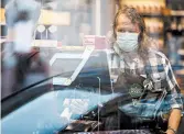  ?? TING SHEN/THE NEW YORK TIMES ?? A cashier wears a face mask amid the pandemic April 14 in Washington. Some chains are now ending “hero” raises.