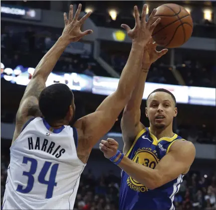  ?? RICHARD W. RODRIGUEZ — THE ASSOCIATED PRESS ?? Stephen Curry, right, passes around the Mavericks’ Devin Harris on Sunday. Curry was 17-for-32shooting but also had five assists in the win.