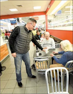  ?? NWA Democrat-Gazette/FLIP PUTTHOFF ?? Guy Mace delivers coffee to Rally’s customers Ted and Clara Fields at the Wal-Mart Supercente­r in Bentonvill­e earlier this month.