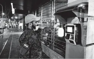  ?? Associated Press file photo ?? A Revolution­ary Guard member disinfects an ATM to try to prevent the spread of the new coronaviru­s in Tehran, Iran. The Islamic Republic has reported 5,823 cases.