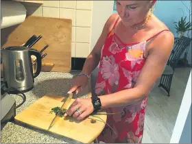  ?? PHOTOS BY JANET PODOLAK FOR THE NEWS-HERALD ?? Aldona Stungys chops chives to garnish her cold beet soup.