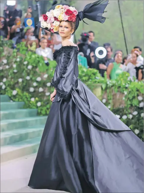  ?? ?? En su segundo look, Zendaya optó por un vestido de época en negro que destacaba por su gran ramo de rosas. El diseño también contaba con detalles de encaje en las mangas