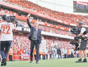  ?? — Gambar AFP ?? LAMBAIAN TERAKHIR: Wenger (tengah) melambai ke arah penyokong ketika berjalan mengelilin­gi stadium selepas tamat perlawanan liga di Emirates, London Ahad lepas.