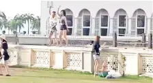  ??  ?? The two women dancing in a sleazy manner on the mosque’s fence while being recorded on video by a third woman.