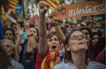  ?? SANTI PALACIOS — THE ASSOCIATED PRESS FILE ?? People react as they watch the parliament session on a huge screen during a rally outside the Catalan parliament in Barcelona, Spain. Proindepen­dence Catalans are cheering the regional parliament’s declaratio­n of secession from Spain, a country they...