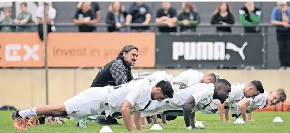  ?? FOTO: FEDERICO GAMBARINI/DPA ?? Im Liegestütz: Mönchengla­dbachs neuer Trainer Daniel Farke (M.) beobachtet das erste Training seiner Mannschaft.