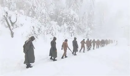  ?? AFP ?? Army soldiers clear a road covered with snow in Murree, around 70 kilometres northeast of the Pakistani capital, Islamabad.